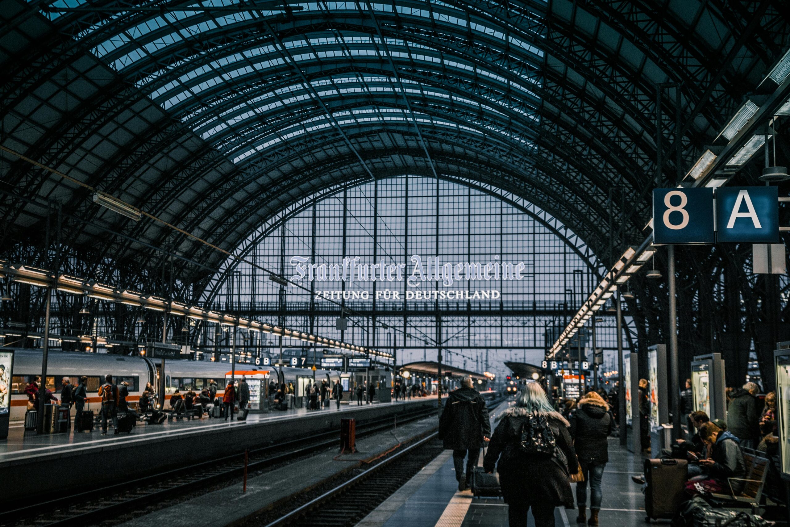 Interior view of Frankfurt Hauptbahnhof with trains and commuters.